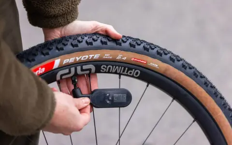 Checking the mountain bike tire pressure with a digital gauge. The tire reads 27.3 PSI.