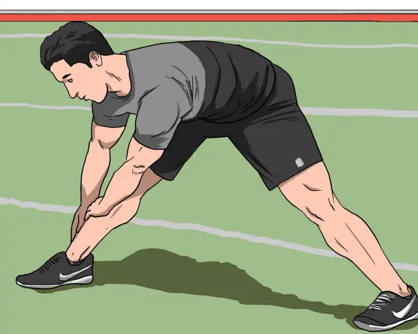 Man stretching his legs on a green indoor track, preparing for an intense indoor sprint workout.