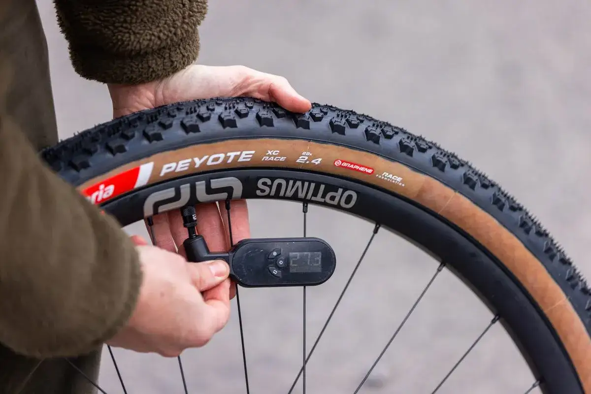 Checking what psi should mountain bike tires be. A digital gauge reads 27.3 psi on a Peyote XC Race tire.
