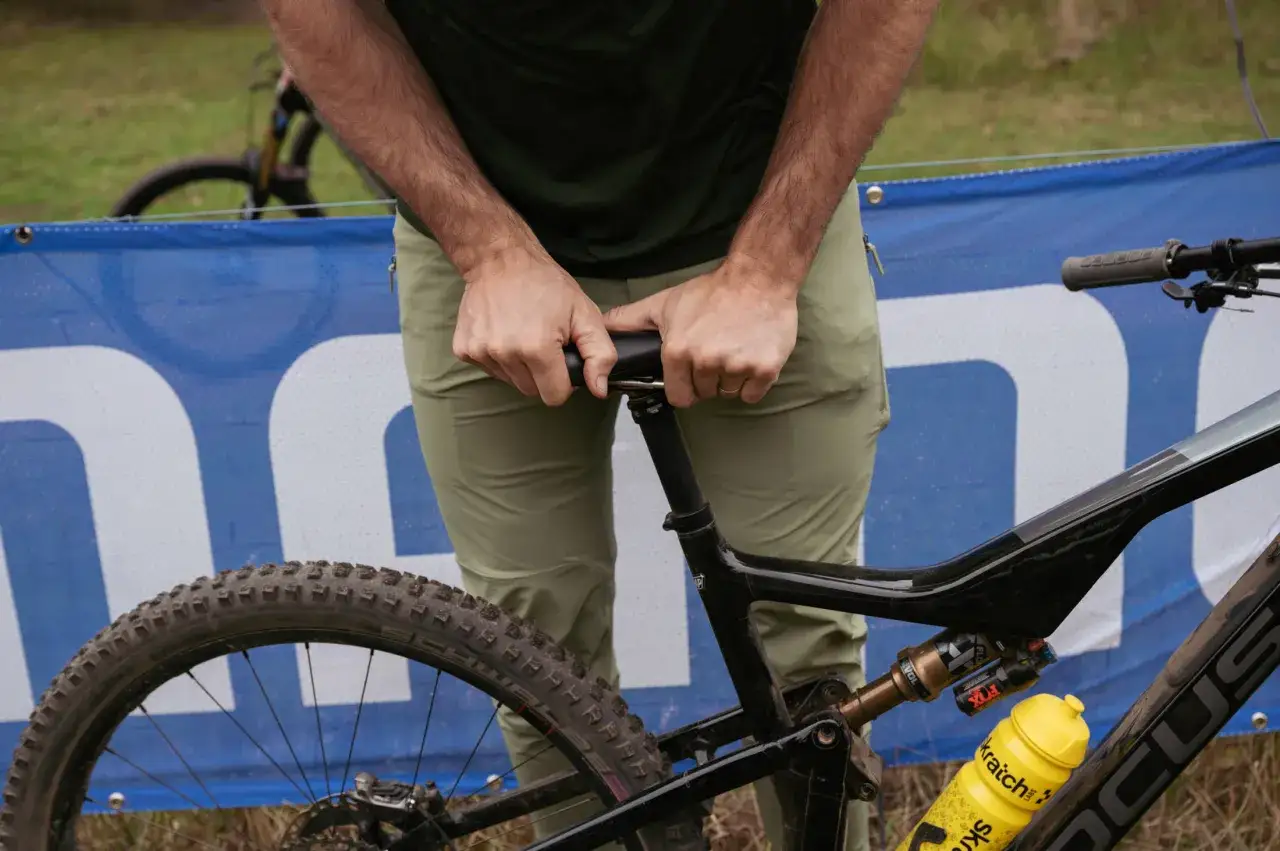 A rider adjusts the seat of their enduro mountain biking rig, ready for the next challenging descent.